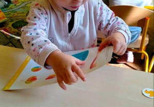 Dziecko podczas wykonywania zadania z użyciem karty pracy.