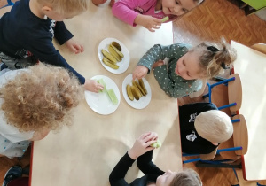 Dzieci konsumują ogórki kiszone.