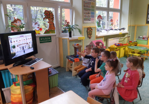 Dzieci oglądają prezentację multimedialną o Zgierzu.