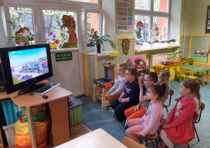 Dzieci oglądają prezentację multimedialną o Zgierzu.