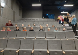 dzieci siedzą na krzesłach w kinie