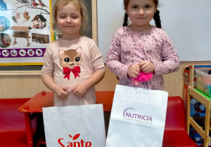 dwie dziewczynki trzymają prezenty