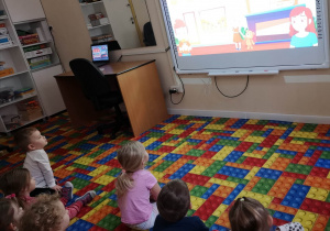 dzieci oglądają film na tablicy multimedialnej