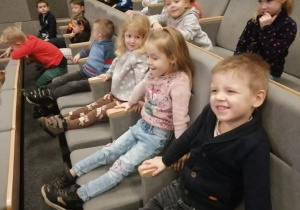 Dzieci siedzą w kinie na fotelach