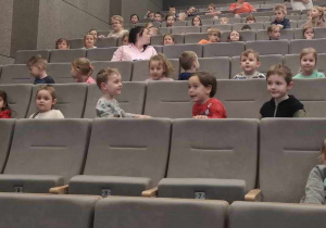 Dzieci siedzą na fotelach w kinie